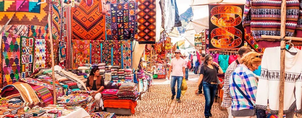 Colorful stalls and local Quechua vendors at the Sunday market in Pisac, Peru | Andean Travel Experience Colorful stalls and local Quechua vendors at the Sunday market in Pisac, Peru | Andean Travel Experience