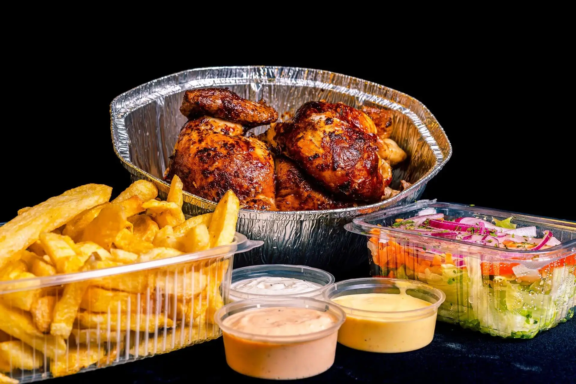 Rostisserie Chicken in Peru with common side dishes such as french fires sauces and salad