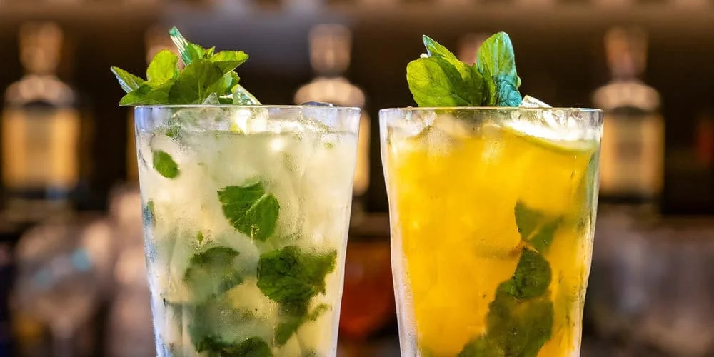 Refreshing Peruvian Chilcano cocktail with Pisco, ginger ale, and lime, served in a highball glass with ice and a lime wedge. | Andean Travel Experience