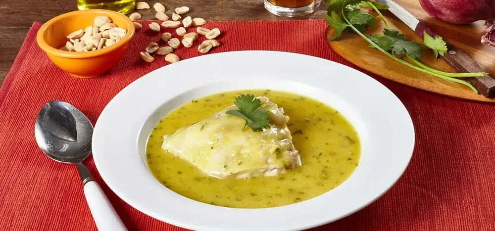 Traditional Peruvian Amazon soup Inchicapi, made with chicken, peanuts, cilantro, and yucca, served warm in a rustic bowl. | Andean Travel Experience