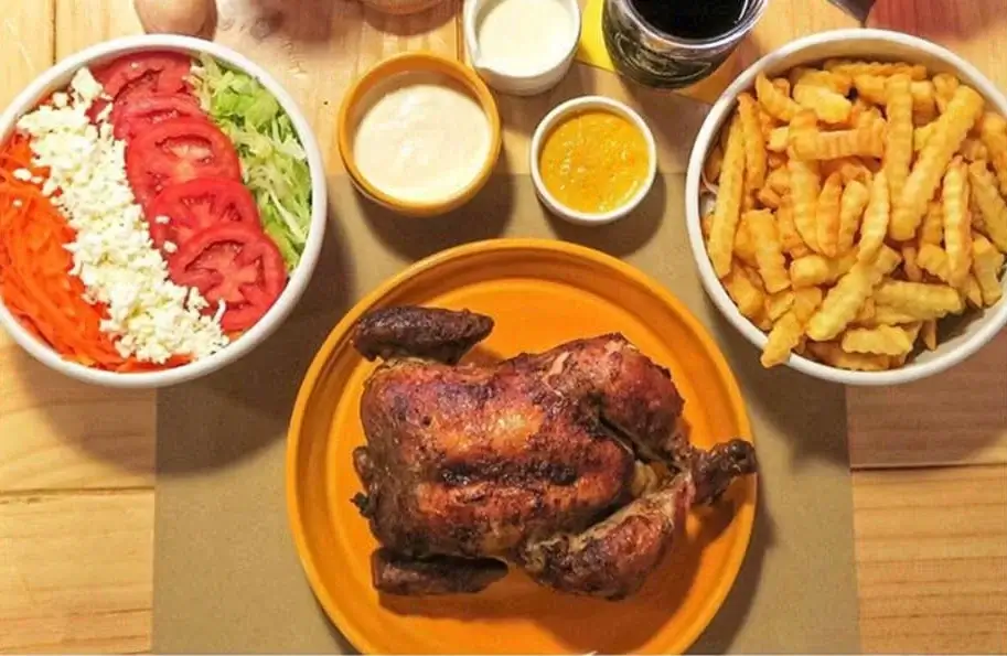 Plate of juicy pollo a la brasa in a local Cusco pollería | Andean Travel Experience