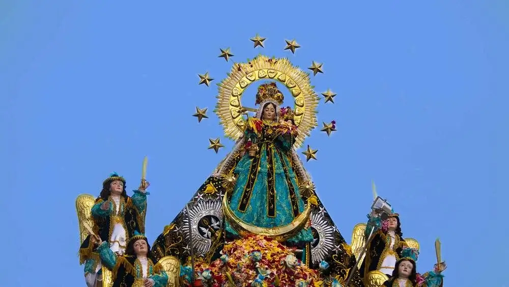 Religious procession carrying the statue of the Virgen de la Candelaria through the streets of Puno, Peru, surrounded by devotees and vibrant decorations. | Andean Travel Experience Religious procession carrying the statue of the Virgen de la Candelaria through the streets of Puno, Peru, surrounded by devotees and vibrant decorations. | Andean Travel Experience