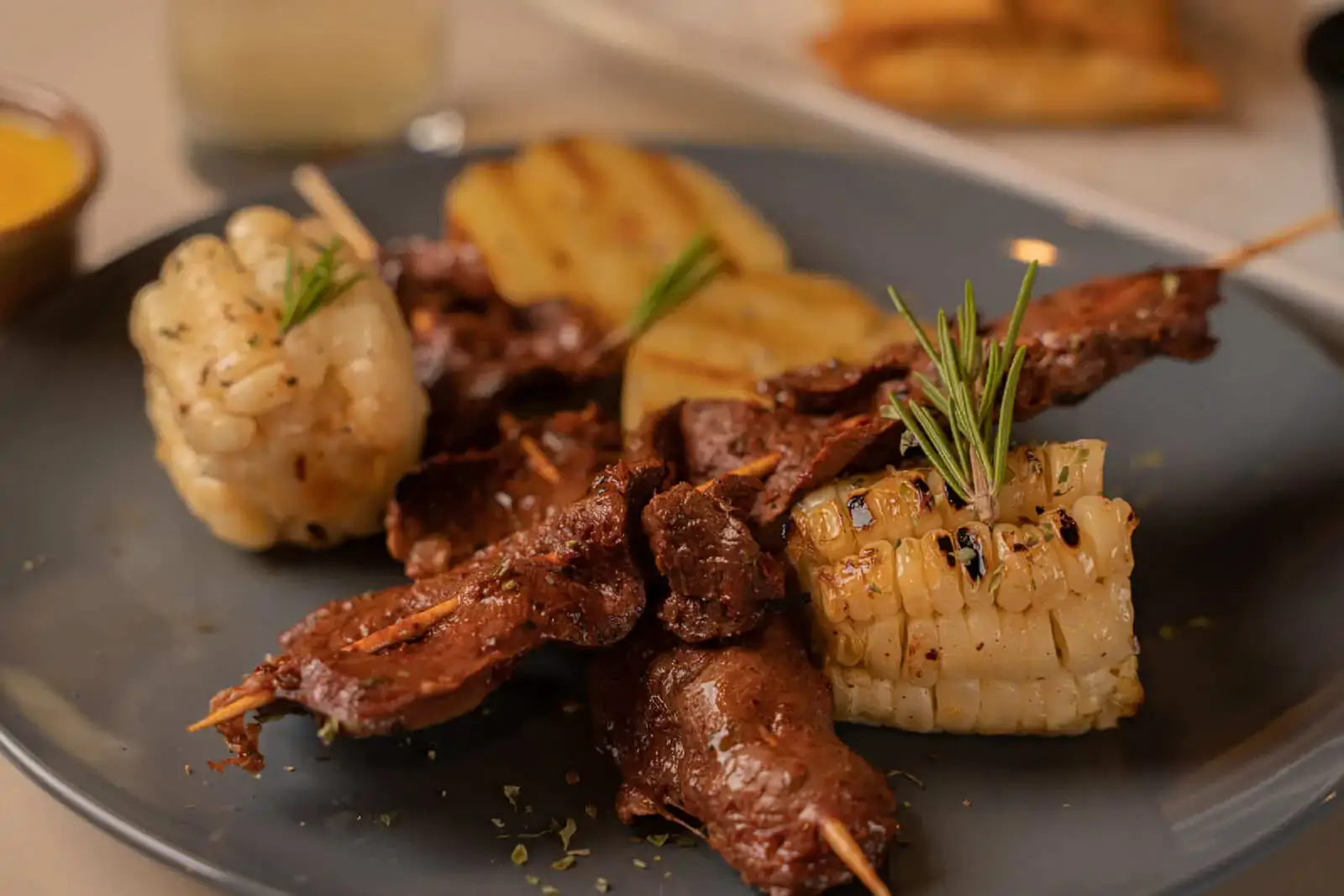 Peruvian anticuchos – grilled beef heart skewers served with potatoes and chili sauce | Andean Travel Experience