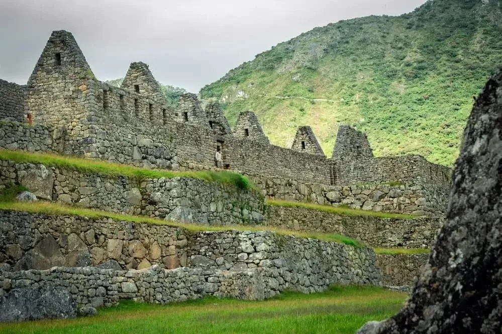 Ancient Inca ruins in Peru surrounded by mountains, showcasing the rich cultural heritage and archaeological legacy of the Andes. | Andean Travel Experience