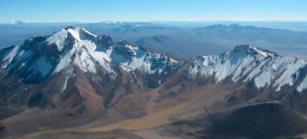 Snow-capped Chachani Volcano rising above the Andean landscape under a clear blue sky. | Andean Travel Experience