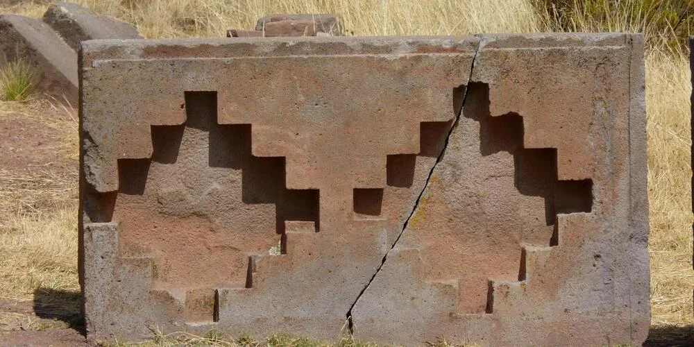 Close-up of a carved Chakana cross, showcasing its stepped geometric design used in Inca symbolism. | Andean Travel Experience Close-up of a carved Chakana cross, showcasing its stepped geometric design used in Inca symbolism. | Andean Travel Experience