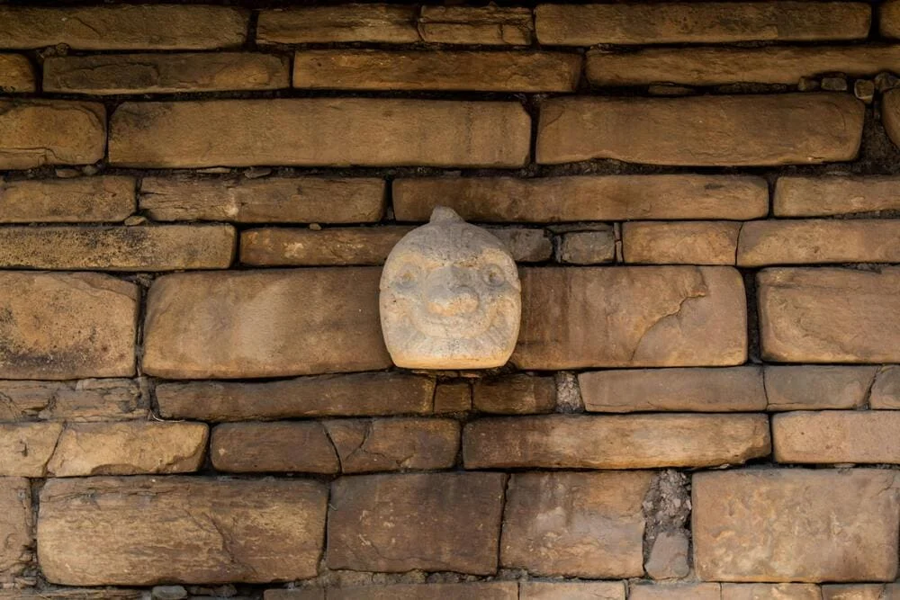 Zoomed detail of Chavín de Huántar sculpted heads known as tenon heads | Andean Travel Experience