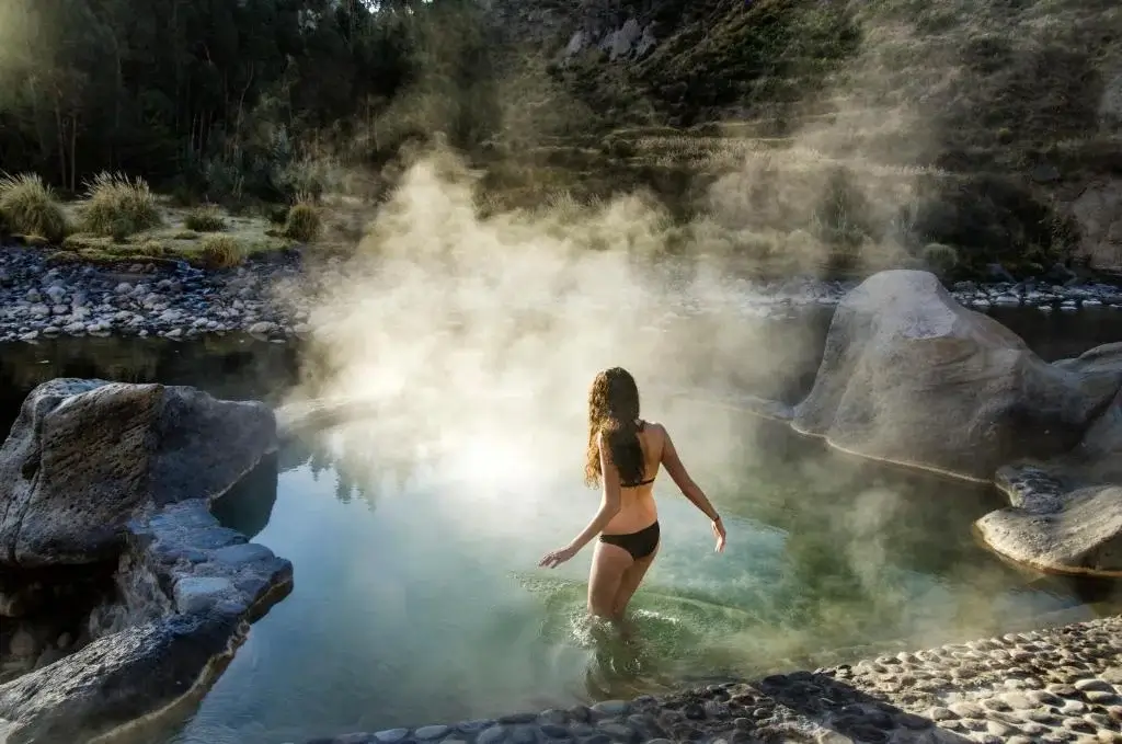 Relaxing natural hot springs in Colca Valley surrounded by lush greenery and mountains | Andean Travel Experience