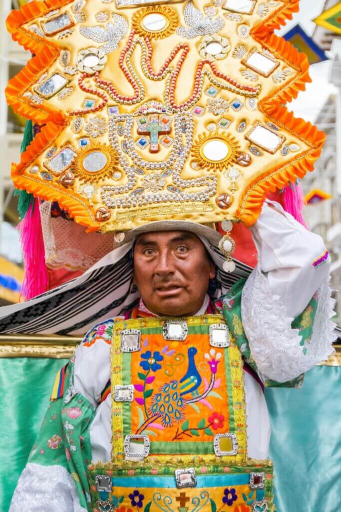 Close-up of a Corpus Christi dancer in Cusco, showing intricate traditional costume and expressive face detail. | Andean Travel Experience 