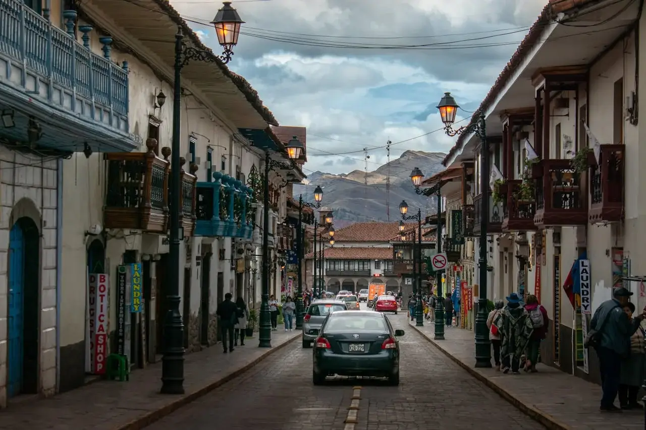 Rainy day in Cusco, Peru, with reflections on the cobblestone streets and historic colonial buildings framed by the Andean mountains | Andean Travel Experience