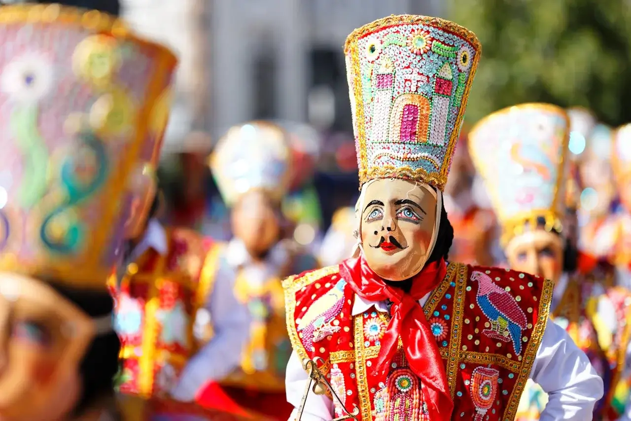 Peruvian dancers wearing traditional masks and vibrant costumes performing during a cultural celebration. | Andean Travel Experience Peruvian dancers wearing traditional masks and vibrant costumes performing during a cultural celebration. | Andean Travel Experience