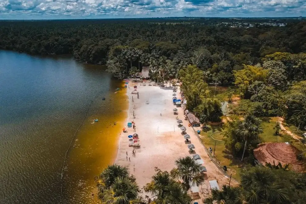 Sandy beach along the Amazon River surrounded by lush rainforest in Peru, a peaceful destination for sustainable travel and ecotourism. | Andean Travel Experience