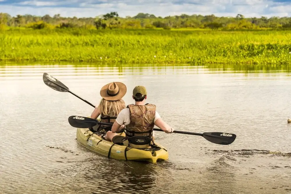 Guest kayaking through a peaceful tributary during a luxury Amazon cruise in the Peruvian rainforest | Andean Travel Experience Guest kayaking through a peaceful tributary during a luxury Amazon cruise in the Peruvian rainforest | Andean Travel Experience