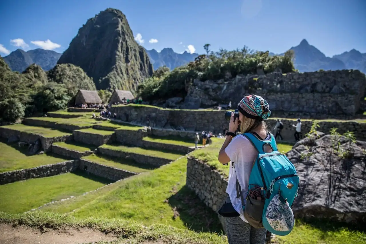 Tourist exploring the ancient Inca citadel of Machu Picchu in Cusco, Peru | Andean Travel Experience