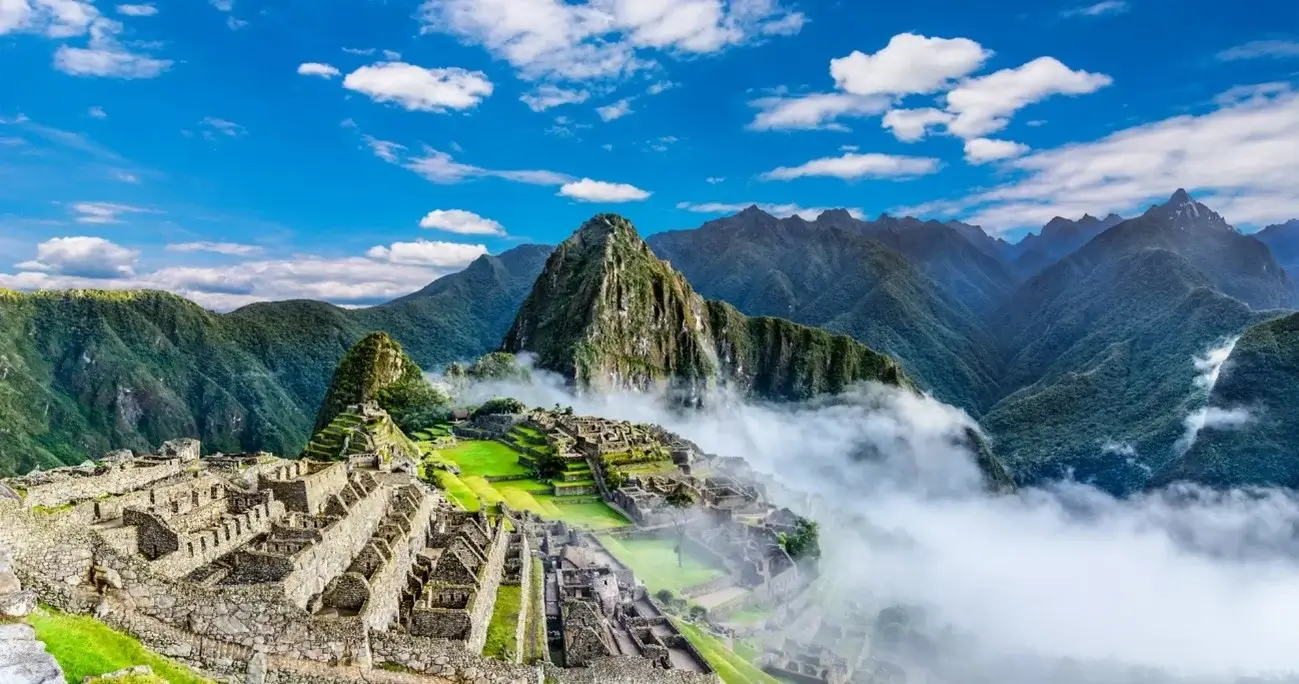 Panoramic view of Machu Picchu, Peru, with the ancient Inca ruins surrounded by the Andes Mountains | Andean Travel Experience