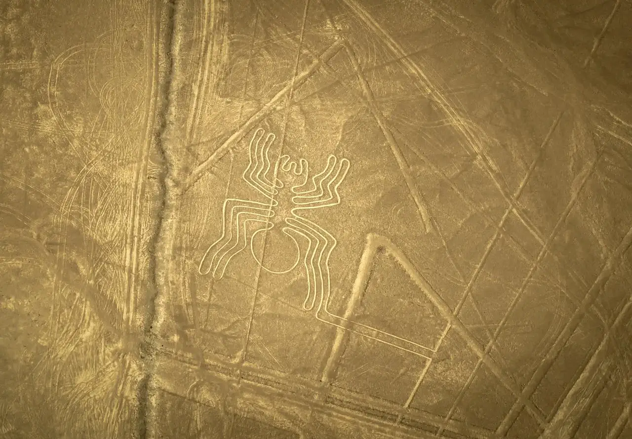 Nazca spider geoglyph with desert landscape in the background | Andean Travel Experience