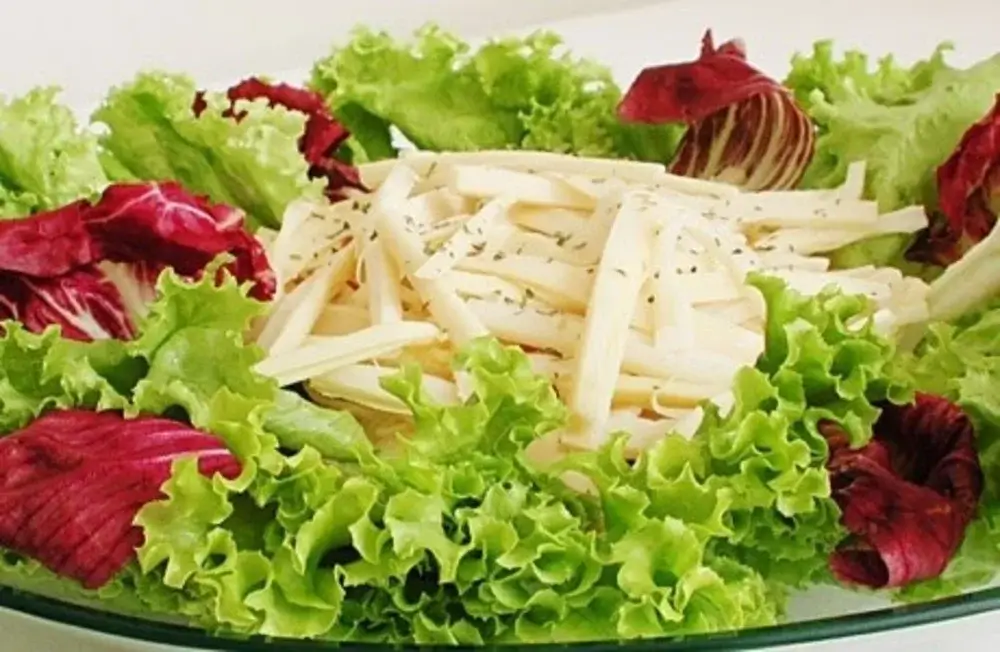 Fresh Amazonian chonta salad made from heart of palm strips, mixed with tomatoes, onions, and lime juice, served as a light and refreshing Peruvian dish. | Andean Travel Experience