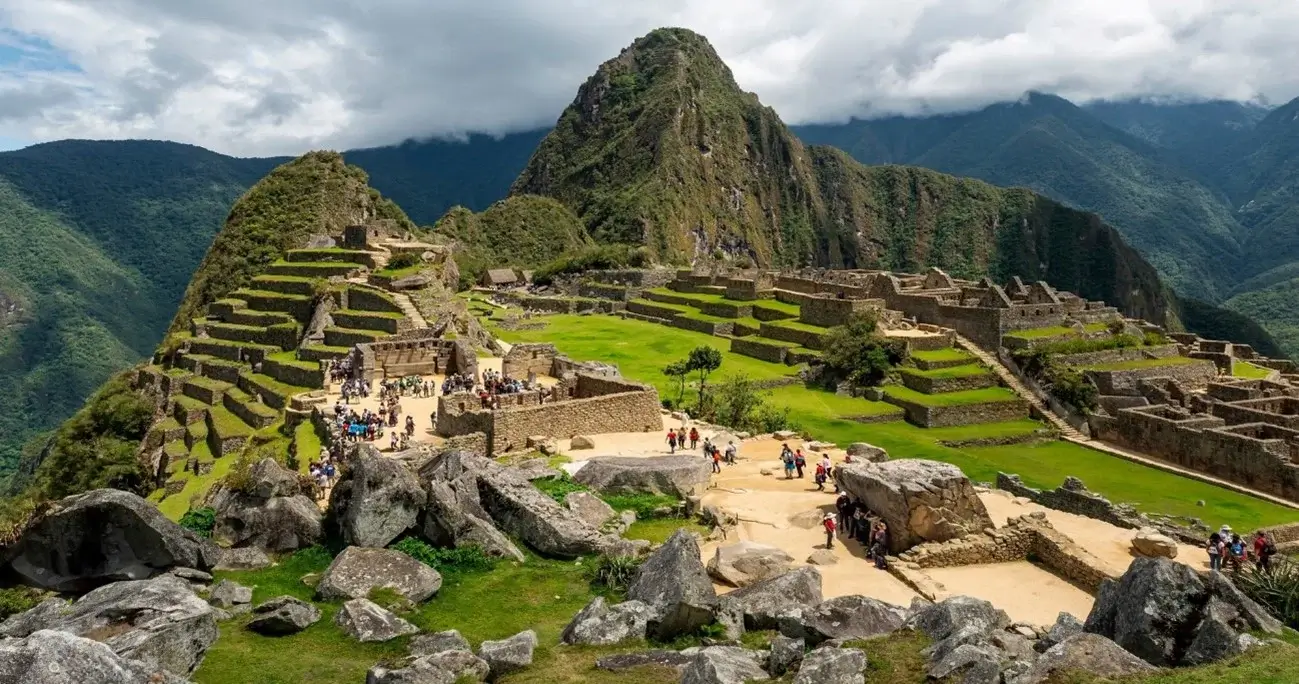 Panoramic view of Machu Picchu, Peru, with the ancient Inca ruins surrounded by the Andes Mountains | Andean Travel Experience