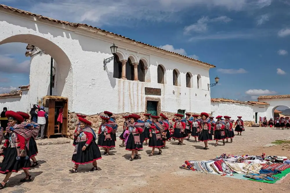 People walking dreesed on Peruvian Textiles on the streets of chincheros a small town in Cusco | Andean Travel Experience