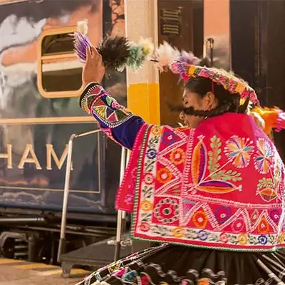 Peruvian woman dancing in traditional costume, showcasing vibrant colors and intricate patterns of her attire | Andean Travel Experience