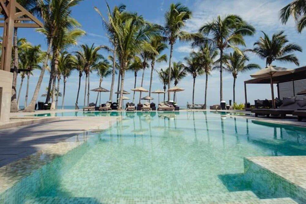 Luxury all-inclusive beachfront resort in northern Peru with white sand, palm trees, and turquoise waters, ideal for relaxing tropical vacations | Andean Travel Experience