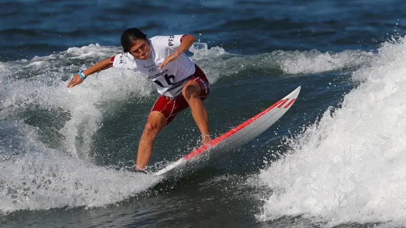 Sofía Mulanovich, Peruvian world surf champion, riding a wave on the ocean and representing female athletic excellence and surf culture in Peru | Andean Travel Experience