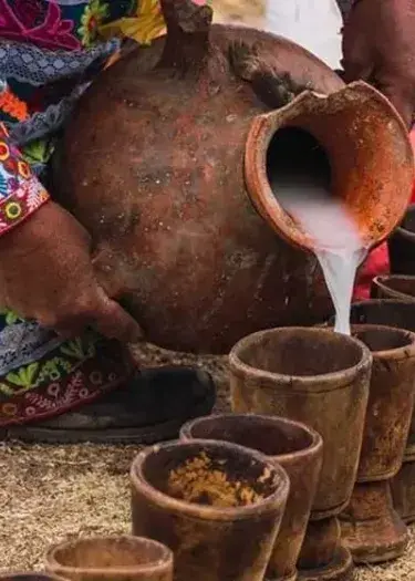 Traditional Chicha de Jora fermented corn drink in a rustic clay cup, representing ancient Incan beverage traditions | Andean Travel Experience