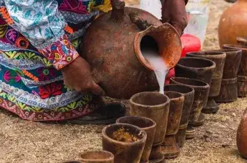 Traditional Chicha de Jora fermented corn drink in a rustic clay cup, representing ancient Incan beverage traditions | Andean Travel Experience