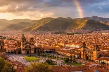 Aerial view of Cusco’s historic center with red-tiled rooftops and colonial architecture in the Peruvian Andes. | Andean Travel Experience