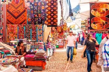 Traditional Andean weavers selling handmade alpaca textiles at Chinchero Market near Cusco | Andean Travel Experience