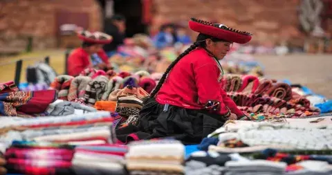 Local woman selling colorful traditional Andean textiles | Andean Travel Experience