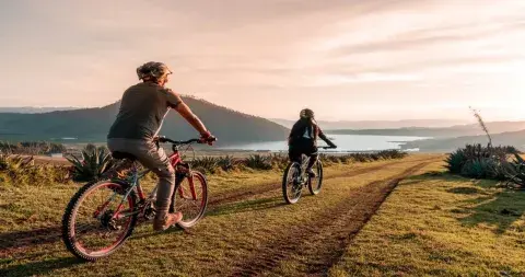 Couple riding bicycles through the scenic landscapes of the Sacred Valley in Peru | Andean Travel Experience