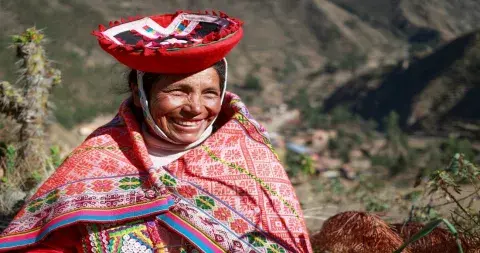 Local woman in traditional clothing laughing joyfully | Andean Travel Experience