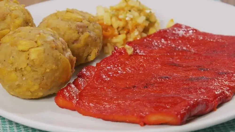Traditional Peruvian Amazon dish tacacho con cecina, featuring mashed green plantains served with grilled smoked pork and sausage. | Andean Travel Experience