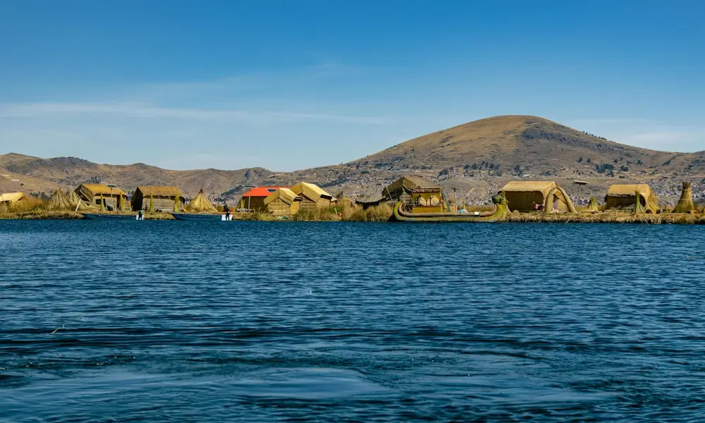 Scenic view of Lake Titicaca in Peru with deep blue waters and surrounding Andean mountains. | Andean Travel Experience