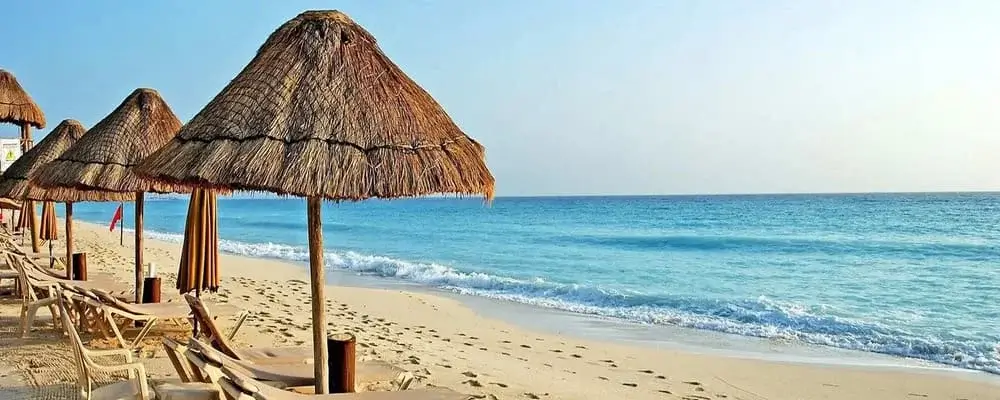 Sunny beach in Máncora, Peru, with golden sand, turquoise waves, and travelers enjoying surfing and relaxation on the Pacific coast | Andean Travel Experience