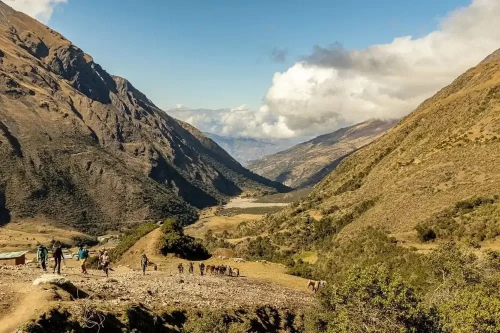 Trail winding through lush green valleys on the way to Machu Picchu via Salkantay | Andean Travel Experience